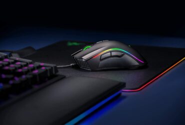 "Razer Mamba Elite gaming mouse with RGB Chroma lighting on a gaming desk."